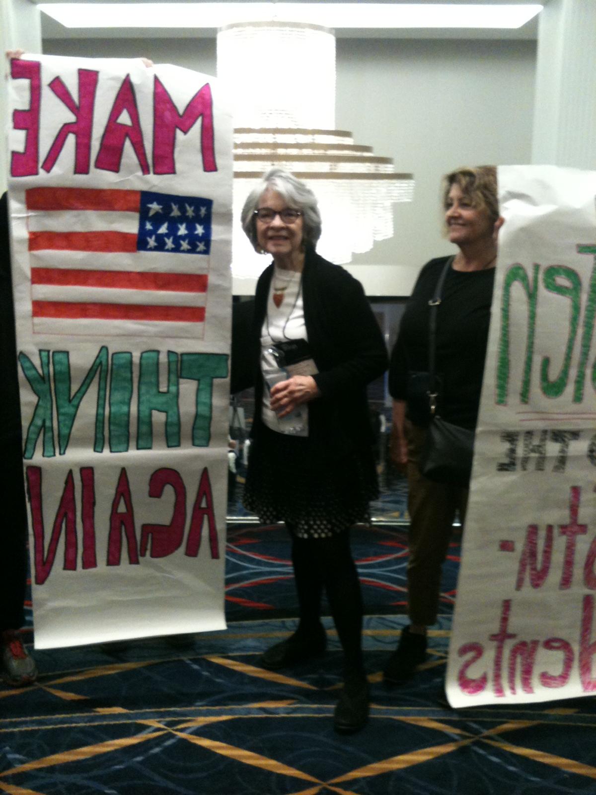 艾菲·罗素举着一张海报，上面写着“让美国重新思考”."
